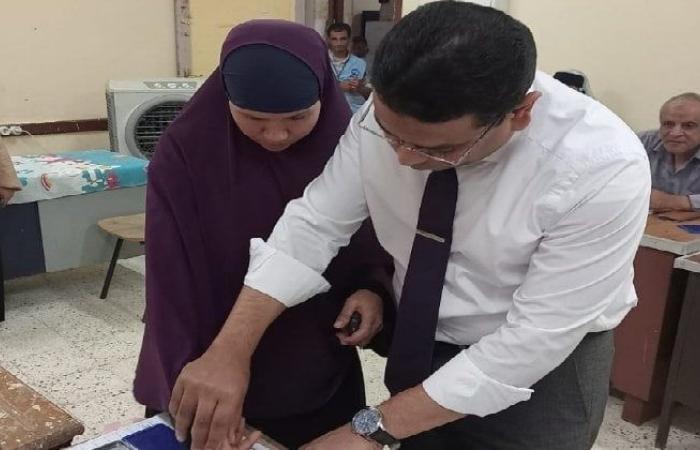 رئيس لجنة بالفيوم يساعد سيدة مسنة كفيفة على الإدلاء بصوتها